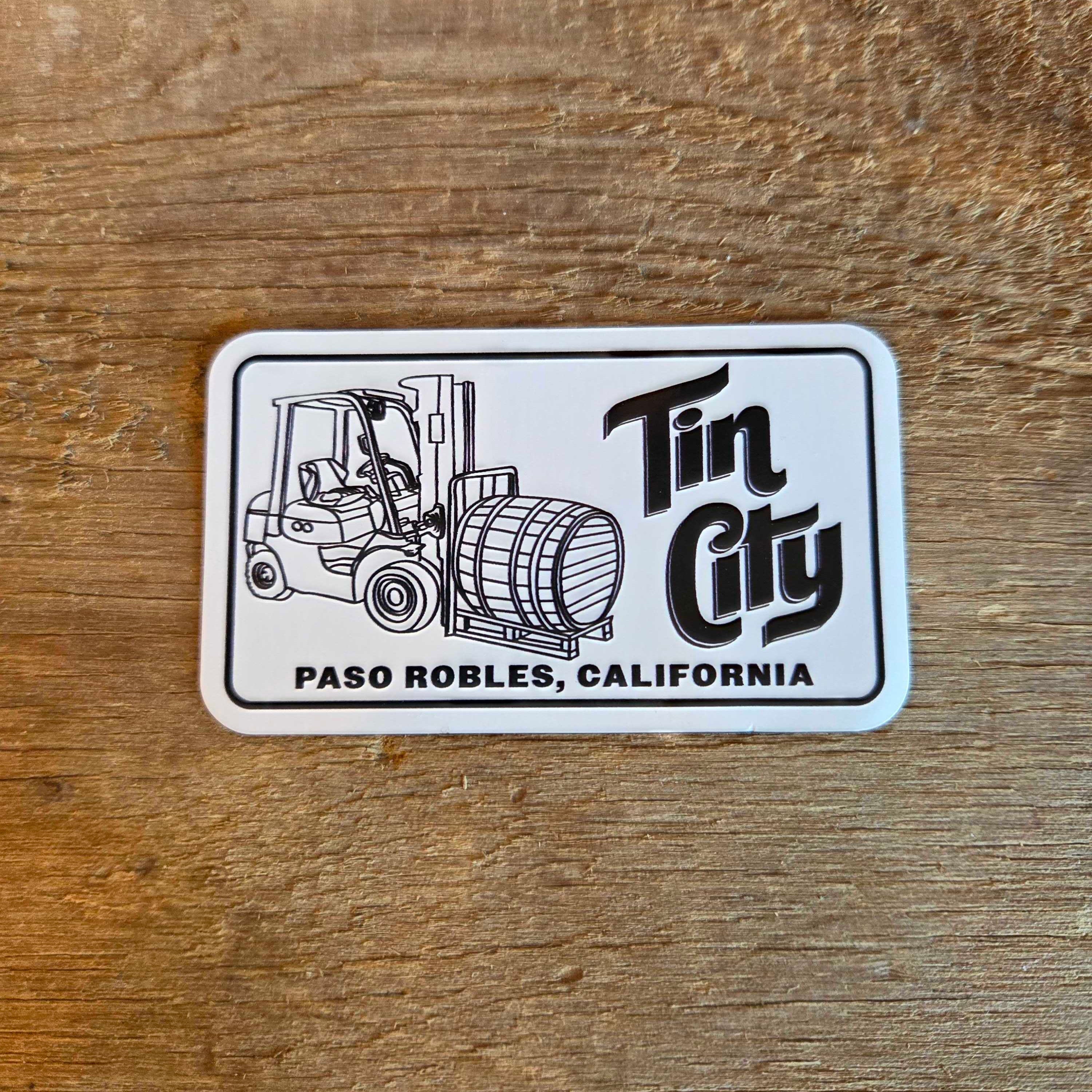 Magnet with a forklift and barrel graphic on a wooden surface