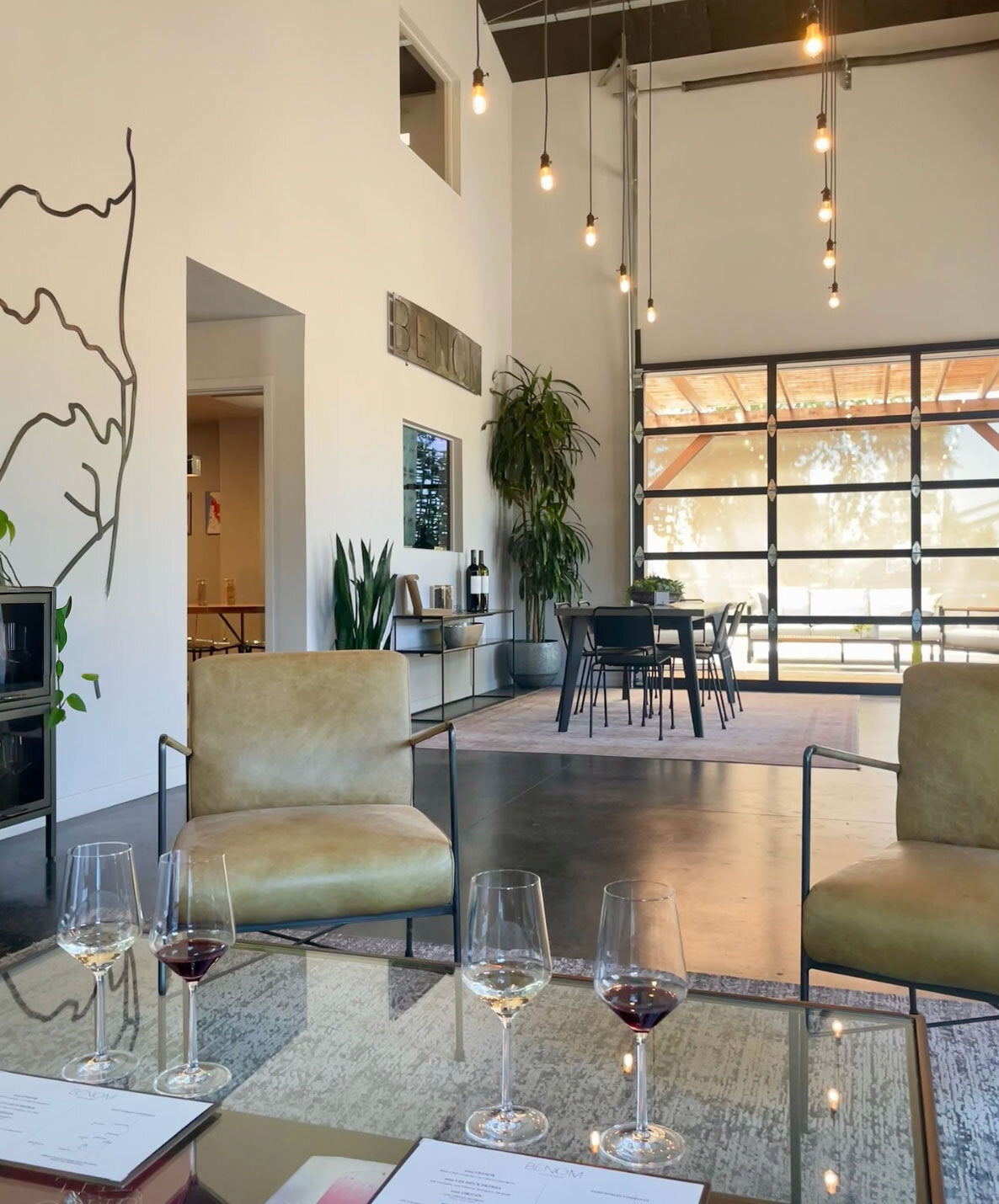Modern interior with chairs, a table, and wine glasses in a stylish setting.